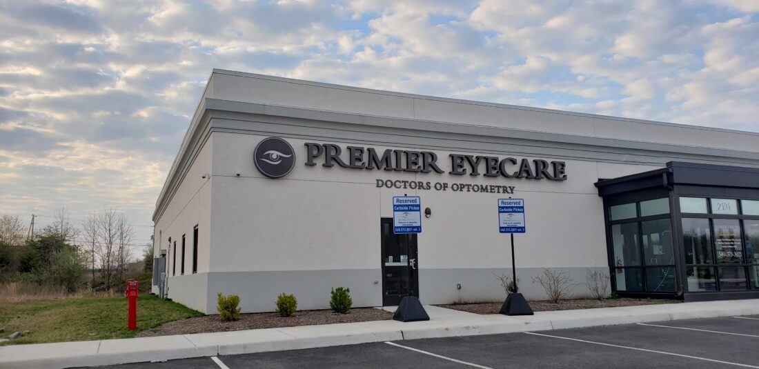 alt="Photo of vibrant bronze halo illuminated channel letter sign for eye doctor in Fredericksburg, Virginia"