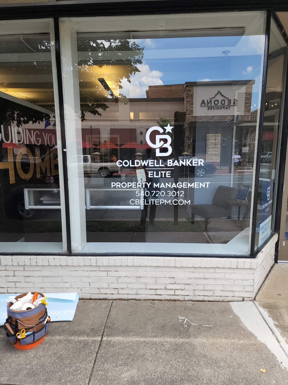 alt="Photo of White vinyl graphics on glass window for local real estate agency located in downtown Fredericksburg, Virginia"