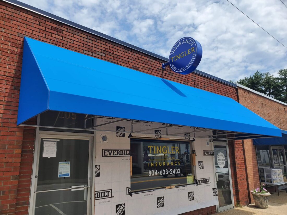 alt="Photo of bright blue and yellow blade sign affixed above newly done bright blue awning located in Bowling Green, Virginia"