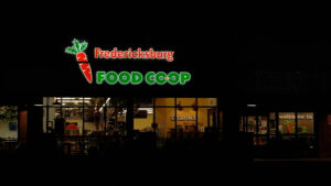 alt="Nighttime image of green and orange grocery store channel letter sign located in Fredericksburg, Virginia"