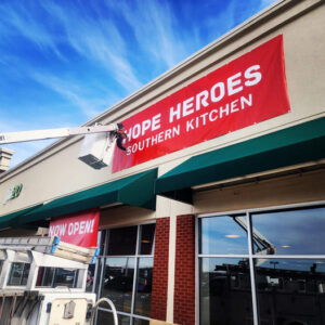 alt="Photo installer doing finishing touches on red restaurant banner located in Spotsylvania, Virginia"