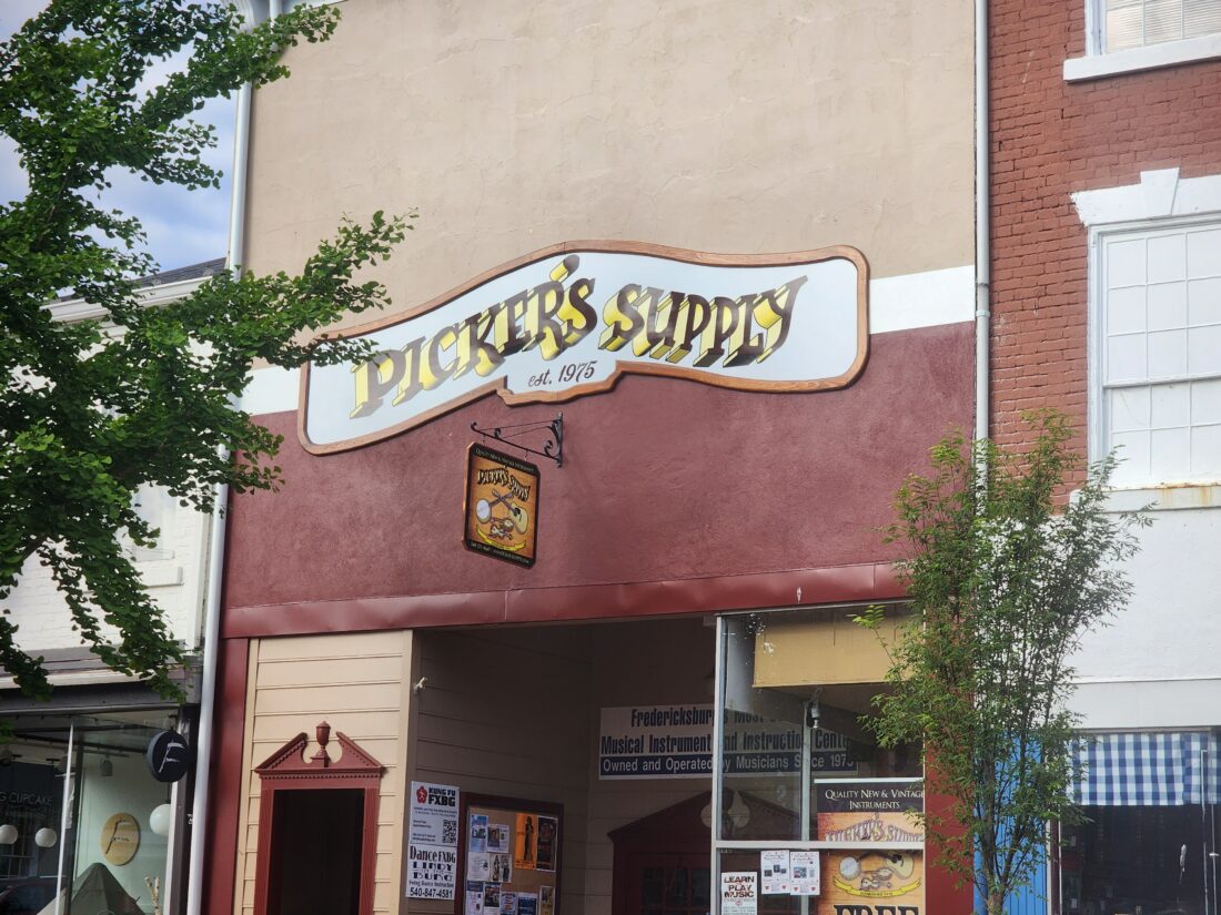 alt="Photo of custom aluminum composite sign wrapped in wood frame and blade sign for guitar shop located in downtown Fredericksburg, Virginia"