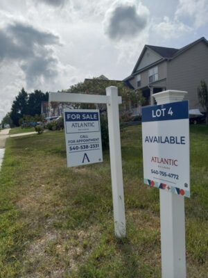 alt="Photo of blue and white real estate signs for Atlantic Builders"