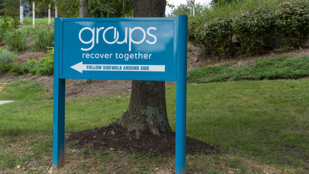 A blue exterior wayfinding sign for Groups - Recover Together in Fredericksburg, VA, created by Distinct Sign Solutions.