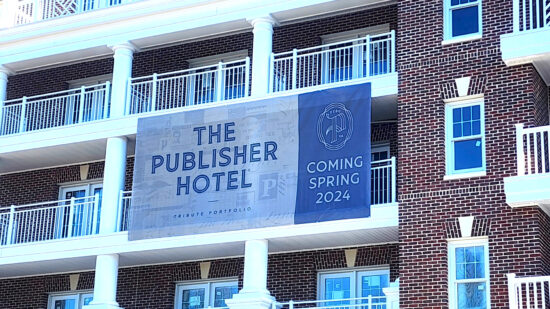 A banner advertising The Publisher Hotel coming in Spring 2024, created by Distinct Sign Solutions (DSS).