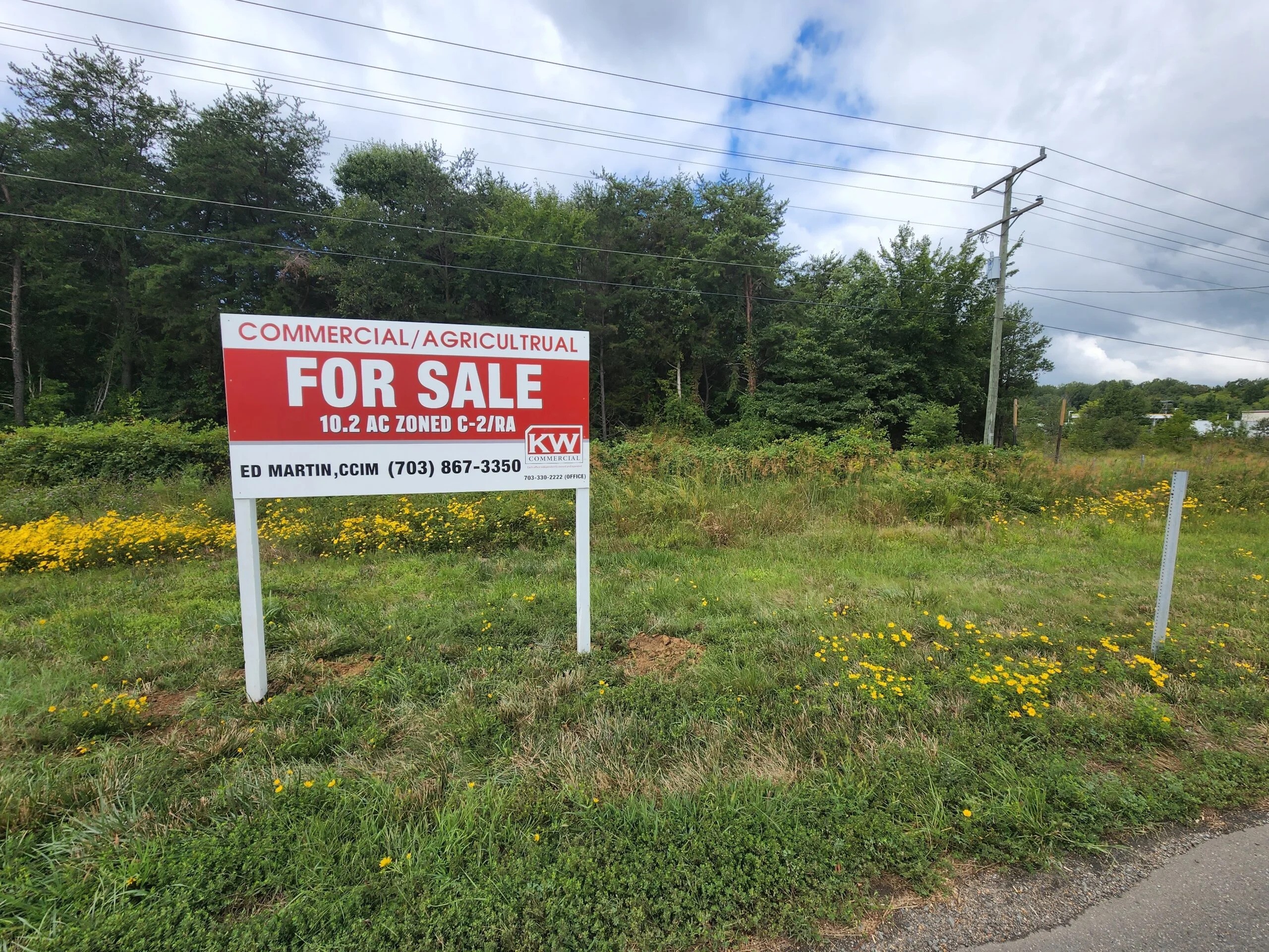 A red commercial real estate sign by Distinct Sign Solutions advertises land for sale in Fredericksburg, VA, with "Keller Williams" branding and contact details.