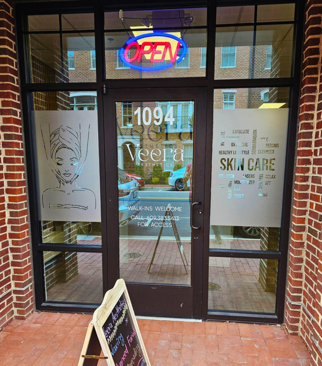 alt="Photo of exterior business entrance door and windows with welded out words and logo in frosted vinyl located in Fredericksburg, Virginia"