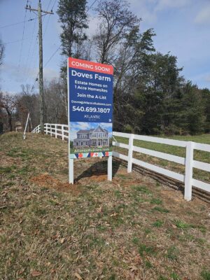 alt="Photo of Vibrant red and blue Atlantic Builders Coming Soon Home Builder sign located in Nokesville, Virginia"