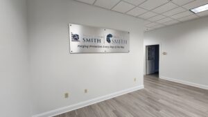 alt="Photo of Teal & White Logo Graphics mounted to brushed aluminum panel installed with black standoffs located in Fredericksburg, Virginia"