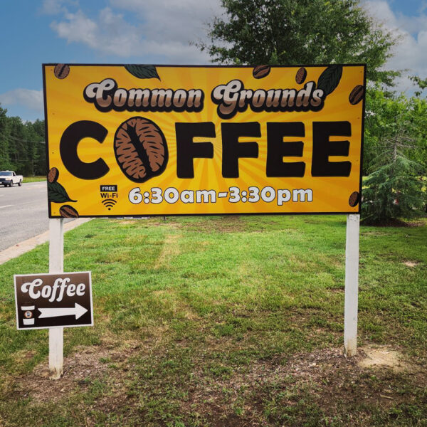 Bright yellow roadside sign for Common Grounds Coffee, using large, bold lettering to highlight the name, with smaller details for operation hours, illustrating a well-executed visual hierarchy.