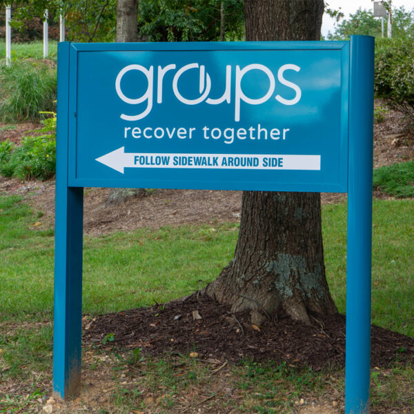 Blue directional sign for Groups Recover Together with a minimalist design and clear font, providing easy guidance and reflecting a modern, clean aesthetic.
