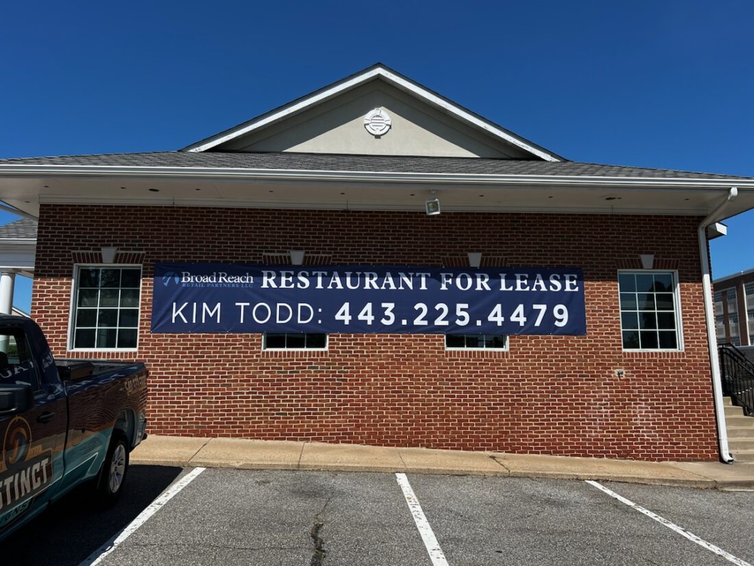 alt="Photo of brick wall with large blue Restaurant for Lease Graphic located in Fredericksburg, Virginia"