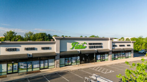 alt="Aerial Photographic displaying large building. Building sign is black and green and dipslays Decks, Patios, Baths, Fletcher Home Improvement Showroom, Roofs, Windows, Doors in Fredericksburg, Virginia"