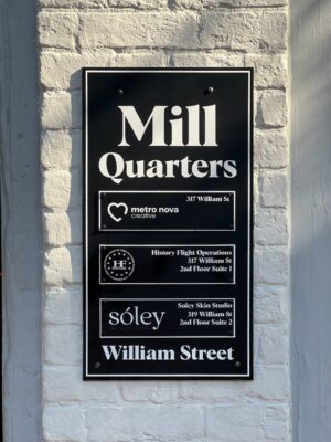 alt="Head On Photo that displays Black & White Modern Directory Sign with MILL QUARTERS header and several tenant panels in Fredericksburg, Virginia"