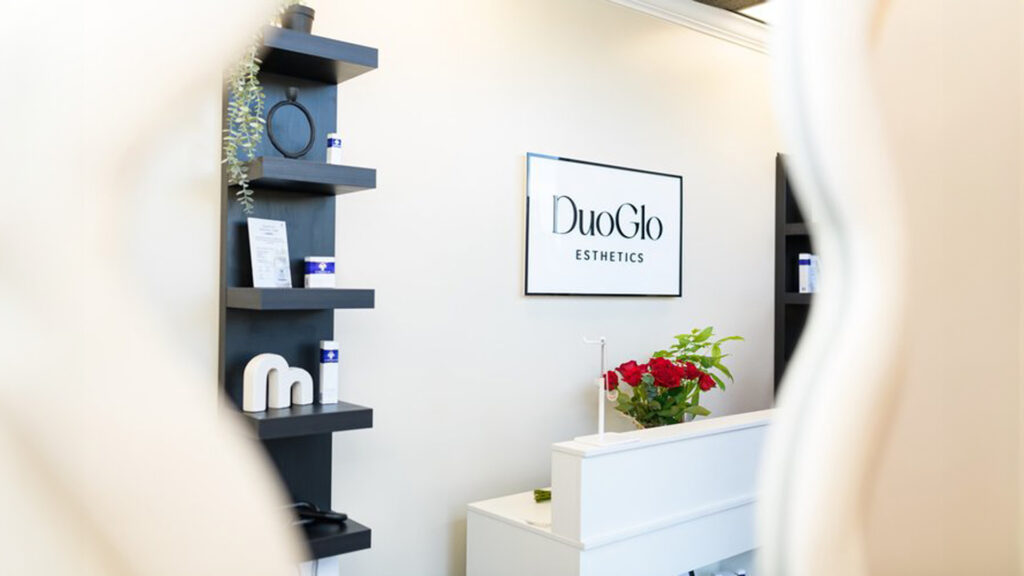 Reception area at DuoGlo Esthetics in Fredericksburg, VA, featuring sleek shelves, products, and the DuoGlo sign.