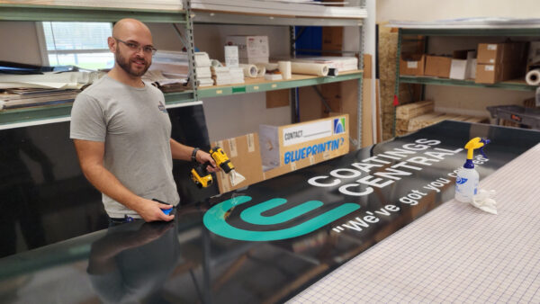 Distinct Signs team member working on signage for Coatings Central in Fredericksburg, VA.