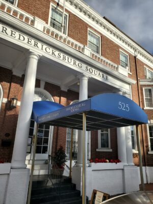 Photo of custom awning with vinyl graphics on oddly shaped awning at Fredericksburg Square. Awning was recovered by Distinct Sign Solutions in Fredericksburg, VA