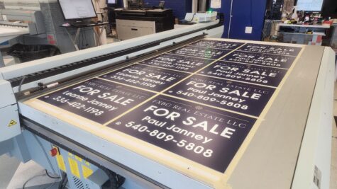 Photo of several aluminum yard signs on flatbed printer in Fredericksburg,VA. Signs were printed by Distinct Sign Solutions in Fredericksburg, VA