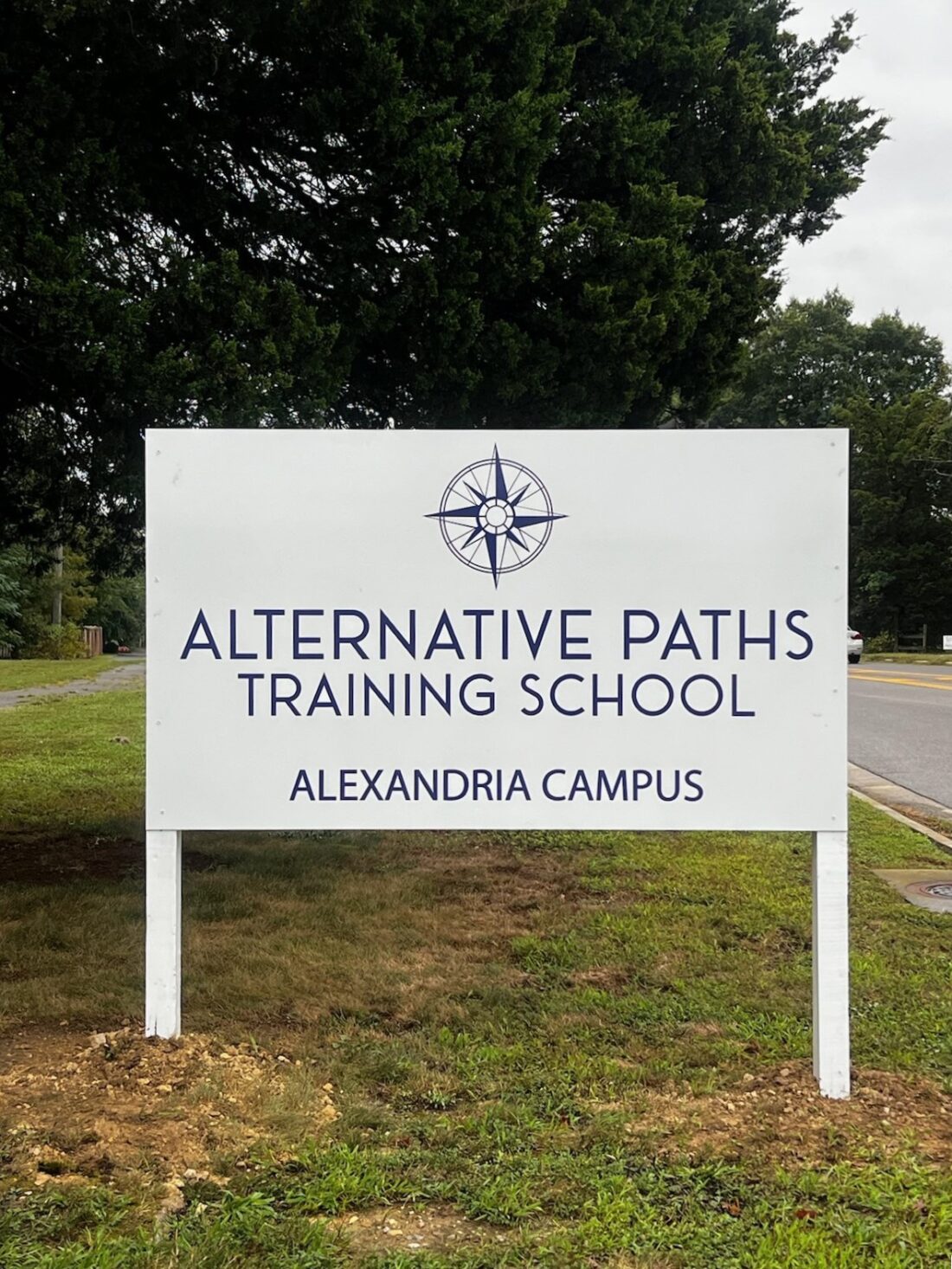 Photo of blue & white post and panel sign in grassy entrance to area at school in Alexandria, VA. Sign was manufactured & installed by Distinct Sign Solutions in Fredericksburg, VA