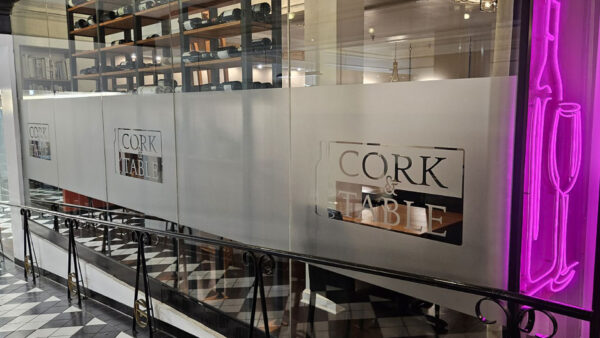 A downtown sign created by Distinct Signs for Cork and Table. Frosted vinyl graphics.