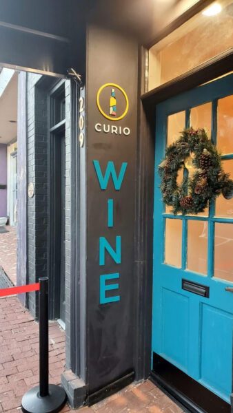 A downtown sign created by Distinct Signs for Curio Wine. Outdoor acrylic sign.