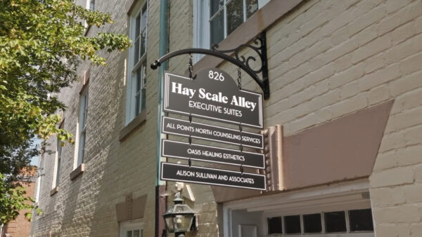 A downtown sign created by Distinct Signs for Hay Scale Alley Executive Suites. Wayfinding blade sign.