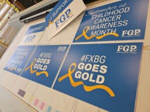 Photo of several newly printed yard signs on flatbed printer. Signs were printed by Distinct Sign Solutions in Fredericksburg, VA