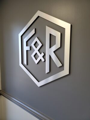 Photo of brushed aluminum acrylic wall sign in lobby at engineering firm in Spotsylvania, VA. Sign was manufactured & installed by Distinct Sign Solutions in Fredericksburg, VA a