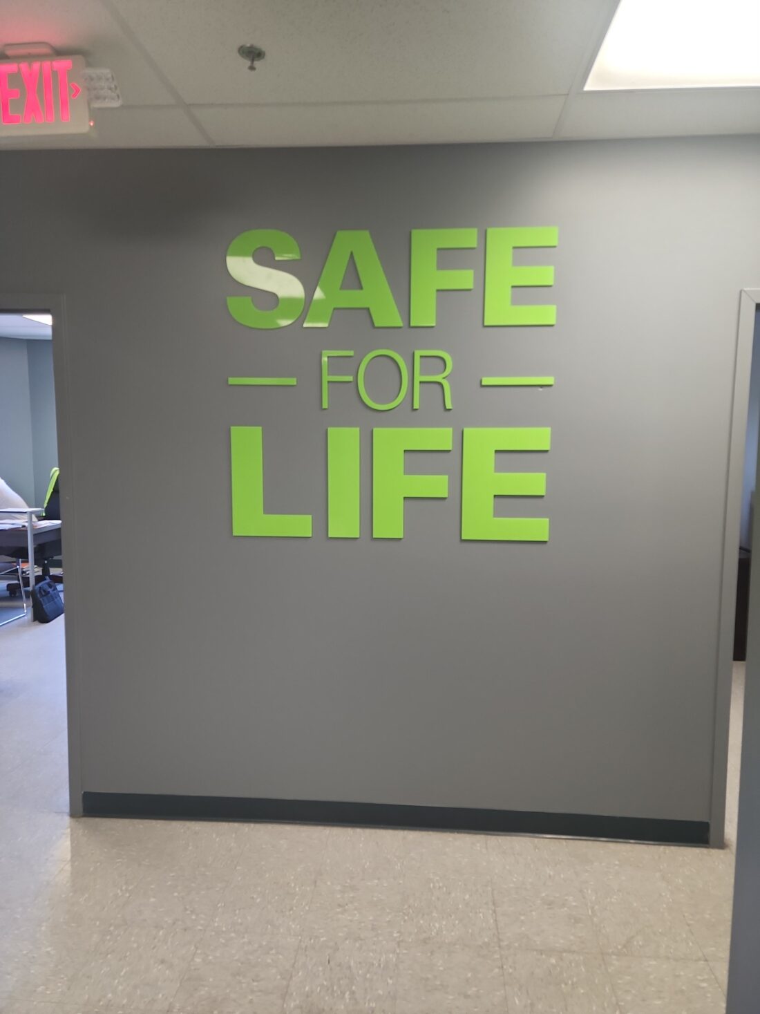 Photo of lime green acrylic wall sign mounted to drywall in Spotsylvania, VA. Sign was manufactured & installed by Distinct Sign Solutions in Fredericksburg, VA.