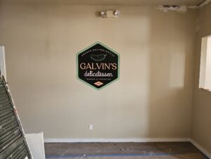 Photo of Galvin's Deli logo mounted to wall in local downtown deli in Fredericksburg, VA. Graphic was manufactured & installed by Distinct Sign Solutions in Fredericksburg, VA