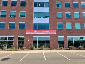 Photo of large red & white banner affixed to brick building in Stafford, VA. Sign was manufactured & installed by Distinct Sign Solutions in Fredericksburg, VA.