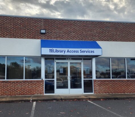 Photo of blue & white awning affixed to building. Awning was manufactured & installed by Distinct Sign Solutions in Fredericksburg, VA