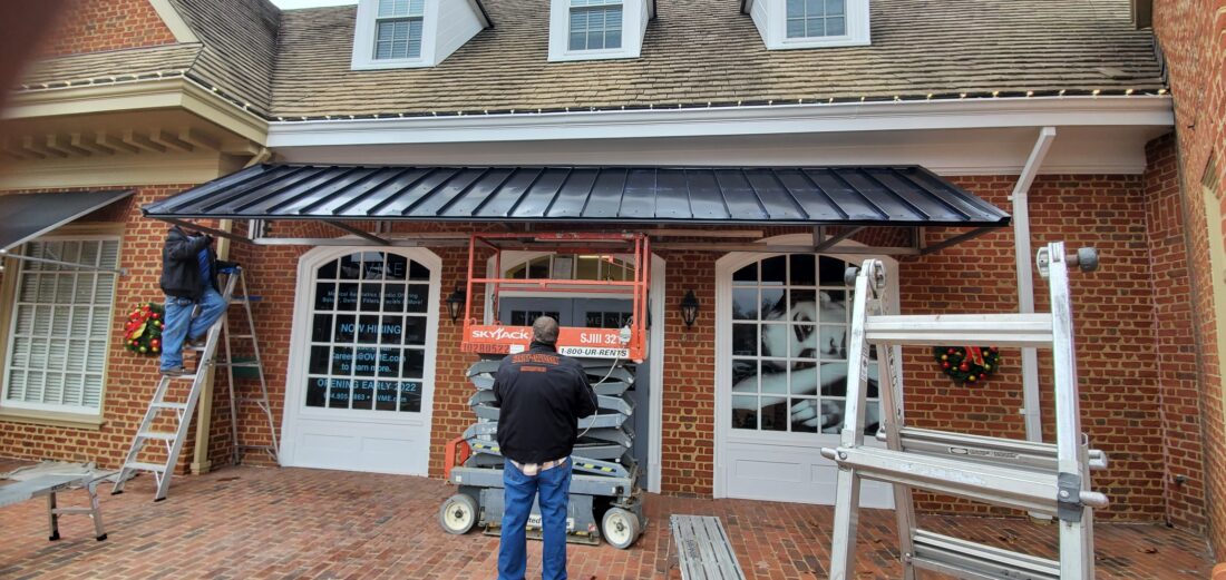 Photo of newly installed black metal awning in Richmond, VA. Awning was manufactured & installed by Distinct Sign Solutions in Fredericksburg, VA.