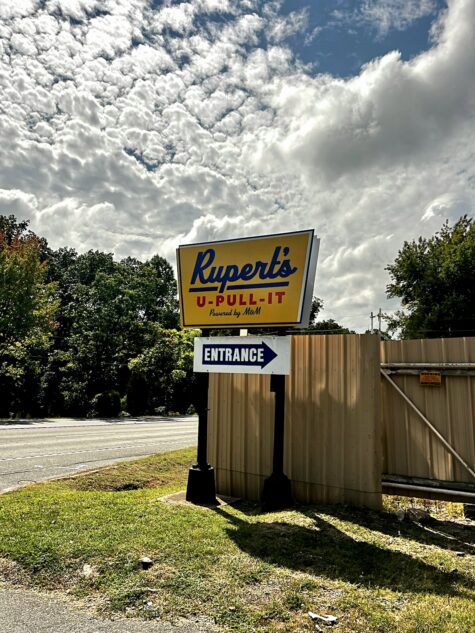 A daytime photo of a newly installed pylon sign with a bold yellow, blue, and red sign stating Rupert's U-Pull-It. Sign is located in Stafford, VA and was manufactured & installed by Distinct Sign Solutions in Fredericksburg, VA