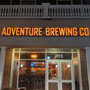 Nighttime photo of Adventure Brewing Co Channel letter sign, located in Fredericksburg, VA. Sign was manufactured & installed by Distinct Sign Solutions in Fredericksburg, VA