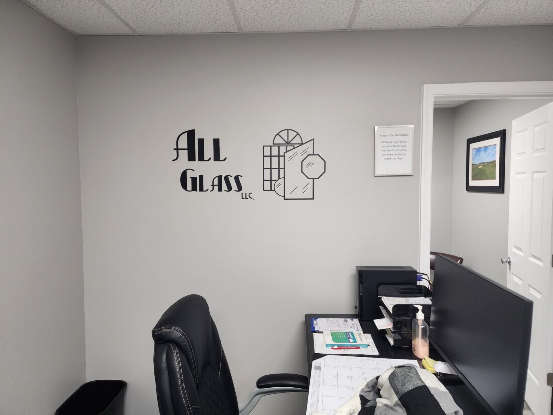 Photo of black vinyl logo graphic on light gray wall in Stafford, VA office. Graphic was manufactured & installed by Distinct Sign Solutions in Fredericksburg, VA