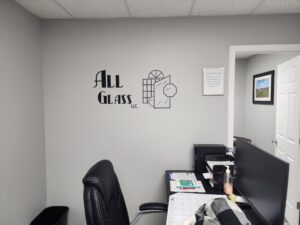 Photo of black vinyl logo graphic on light gray wall in Stafford, VA office. Graphic was manufactured & installed by Distinct Sign Solutions in Fredericksburg, VA