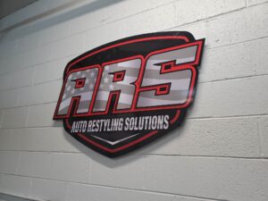 Photo of custom logo sign affixed to block wall in Fredericksburg, VA auto shop. Sign was manufactured & installed by Distinct Sign Solutions in Fredericksburg, VA