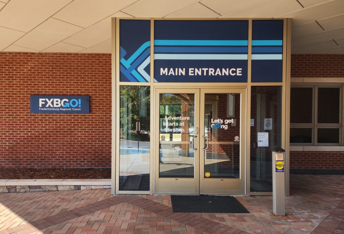 Photo of signs & graphics affixed to entrance of transit location in Fredericksburg, VA. Signs & Graphics were manufactured & installed by Distinct Sign Solutions in Fredericksburg, VA