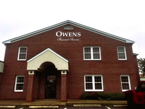 Photo of white acrylic wall sign affixed to brick building in Stafford, VA. Sign was manufactured & installed by Distinct Sign Solutions in Fredericksburg, VA