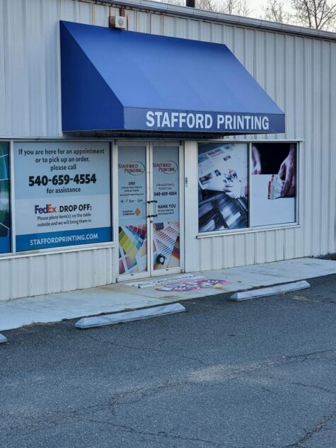 Photo of new blue cover with vinyl graphics for print shop in Stafford, VA. Awning was recovered & installed by Distinct Sign Solutions in Fredericksburg, VA