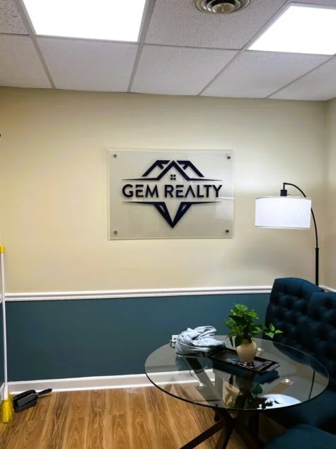 Photo of interior wall mounted frosted acrylic sign with 3D Acrylic logo in property management office in Fredericksburg, VA. Sign was manufactured & installed by Distinct Sign Solutions in Fredericksburg, VA.