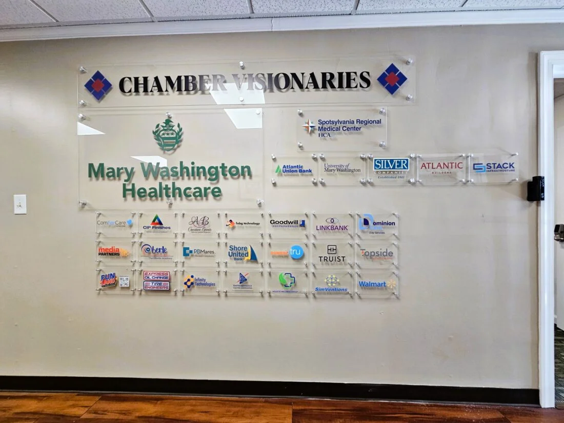 Photo of multiple acrylic wall signs displayed on drywall in entrance of Fredericksburg VA's chamber of commerce. Signs were manufactured & installed by Distinct Sign Solutions in Fredericksburg, VA