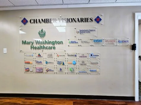 Photo of multiple acrylic wall signs displayed on drywall in entrance of Fredericksburg VA's chamber of commerce. Signs were manufactured & installed by Distinct Sign Solutions in Fredericksburg, VA