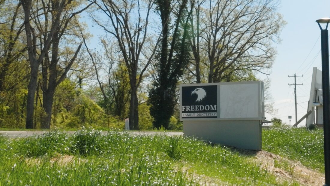 Photo of gray, black and white monument sign on top of grassy hill in Spotsylvania, VA. Sign was manufactured & installed by Distinct Sign Solutions in Fredericksburg, VA