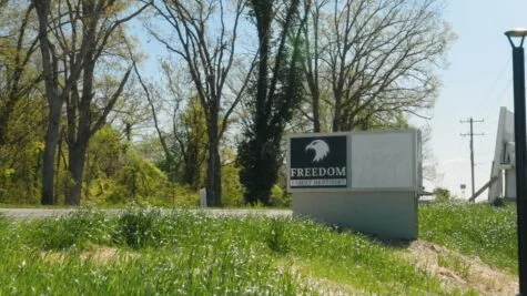 Photo of gray, black and white monument sign on top of grassy hill in Spotsylvania, VA. Sign was manufactured & installed by Distinct Sign Solutions in Fredericksburg, VA