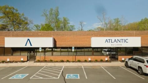 Photo of two acrylic logo signs for Atlantic Builders, mounted to EIFS walls in Fredericksburg, VA. Signs were manufactured & installed by Distinct Sign Solutions in Fredericksburg, VA