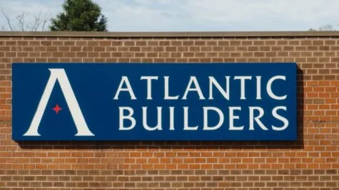 Photo of large Blue, white and red push through acrylic channel letter cabinet sign mounted to brick wall in Fredericksburg, VA. Sign was manufactured & installed by Distinct Sign Solutions in Fredericksburg, VA