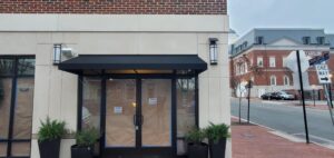 Photo of black fabric awning set on building in Downtown Fredericksburg, VA. Awning was manufactured & installed by Distinct Sign Solutions in Fredericksburg, VA