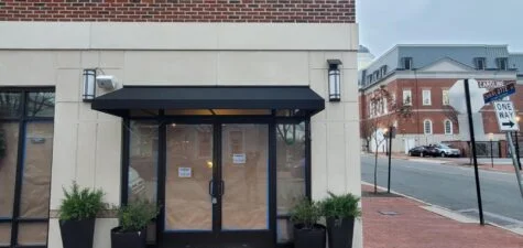 Photo of black fabric awning set on building in Downtown Fredericksburg, VA. Awning was manufactured & installed by Distinct Sign Solutions in Fredericksburg, VA